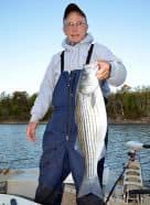 Tom Reynolds with STR Outfitters shows off a striped bass he caught while fishing on Norfork Lake near Mountain Home, Ark. Photo: John N. Felsher