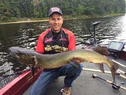 Jim Saric with a big muskie caught, the result of winter research on ‘new’ water. The research yielded key information regarding the water’s color, and potentially, productive lure colors.