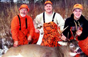 Grandson Tyler with his first buck, along with Doc and Tyler's proud father, Dave.