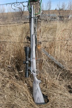 Remington model 700 .50-caliber muzzleloader with scope propped against a fence post. 