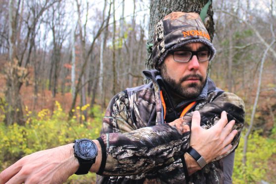 Deer hunter in camo--author Tim Kjellesvik--demonstrating a straight arm stretch important for staying limber during late-season archery outings.