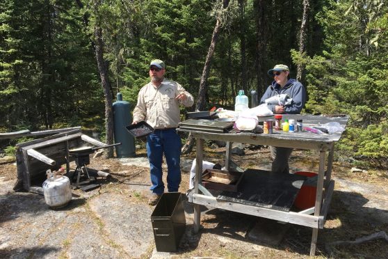 Filet table and portable gas grill--shore lunch cooking spot on Woman River in Ontario.