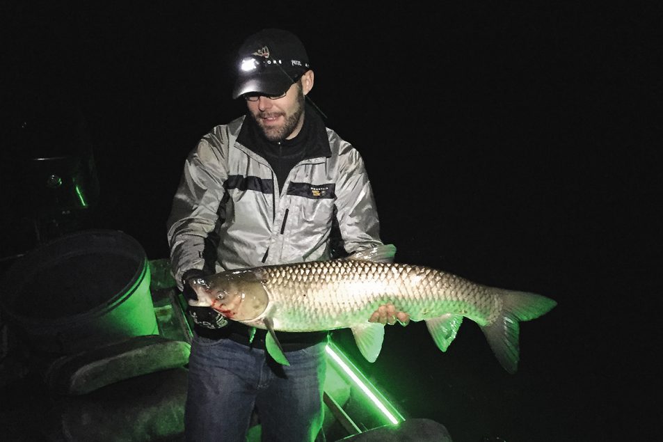 The author with just one of the big grass carp shot on this wintertime outing. Fun fact: two grassies had lampreys attached when we boated them. A bowfishing bonus!