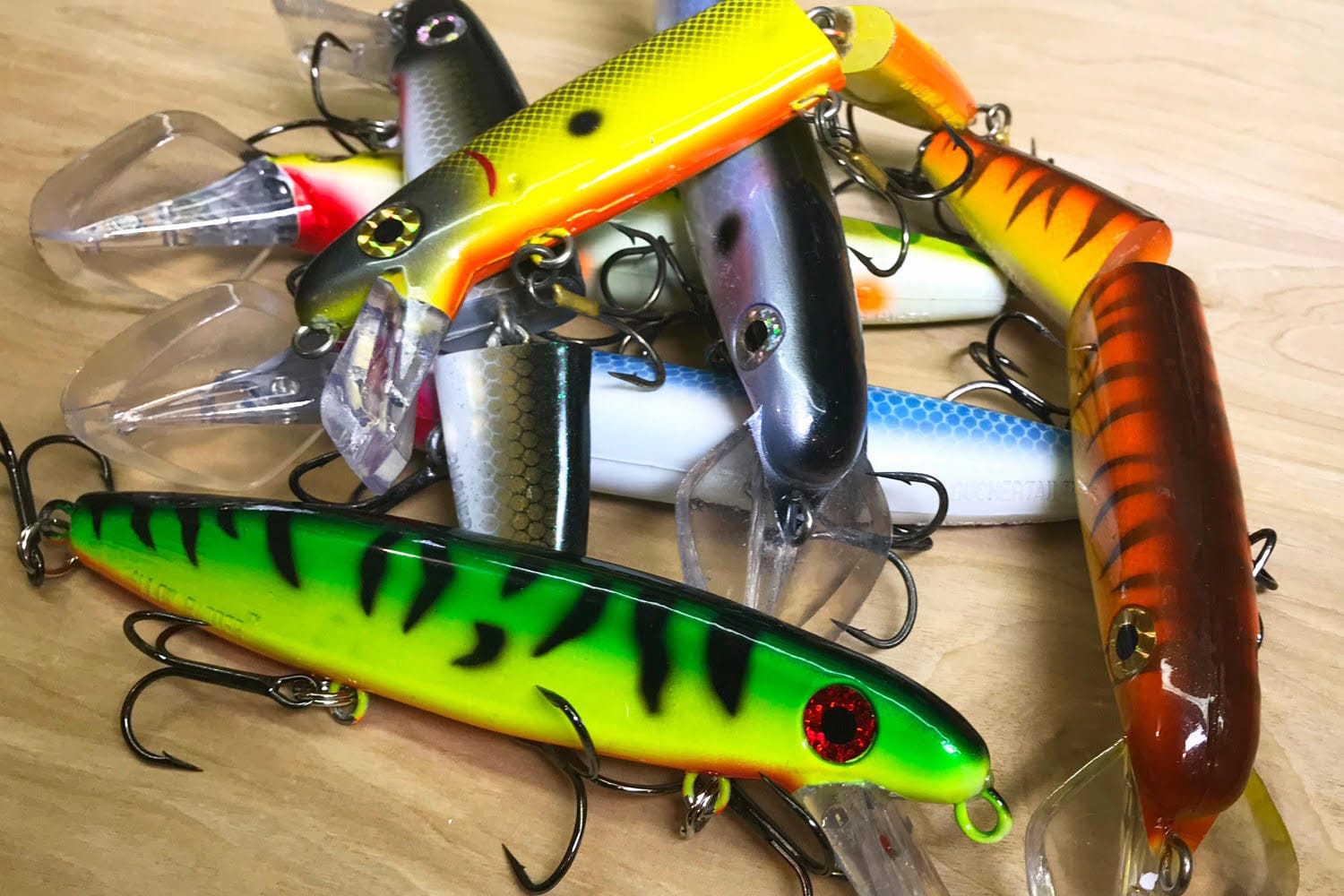 Colorful fishing lures hanging on a shelf along with a fishing